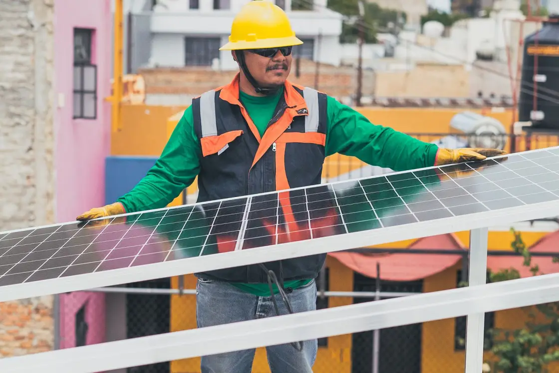 Técnico instalando paneles solares en una azotea en México